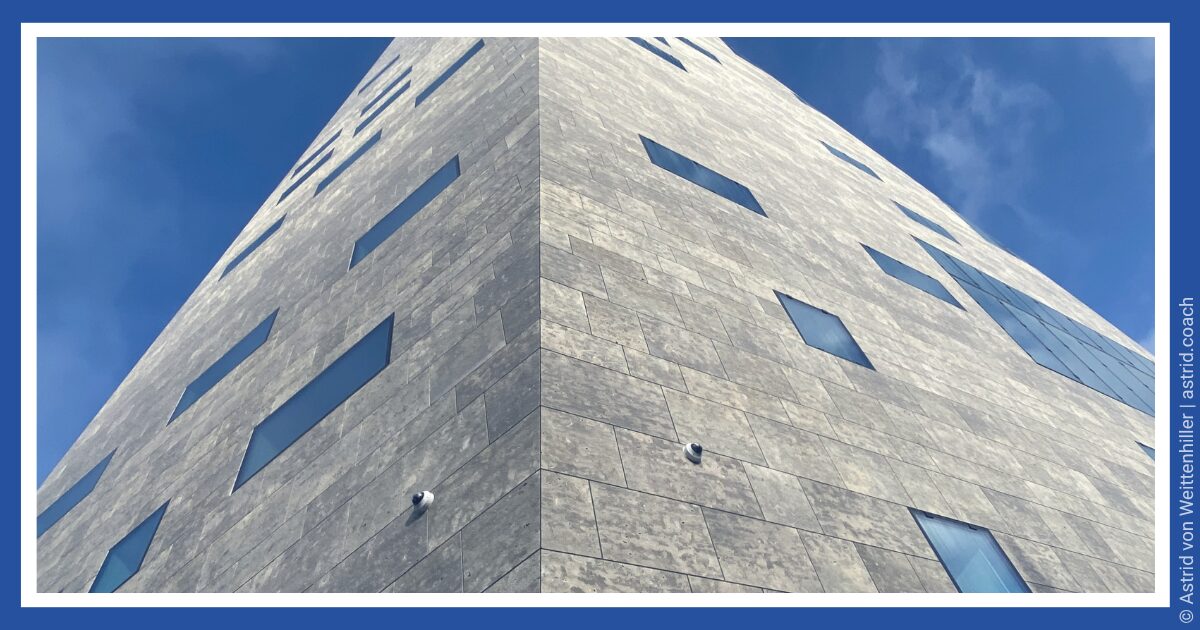 entscheidungsmethoden_decision-making-methods1 Deutsch: Graues Betongebäude unter blauem Himmel bei Tageslicht, minimalistische Architekturaufnahme. English: Grey concrete building under a blue daytime sky, minimalist architectural photograph.