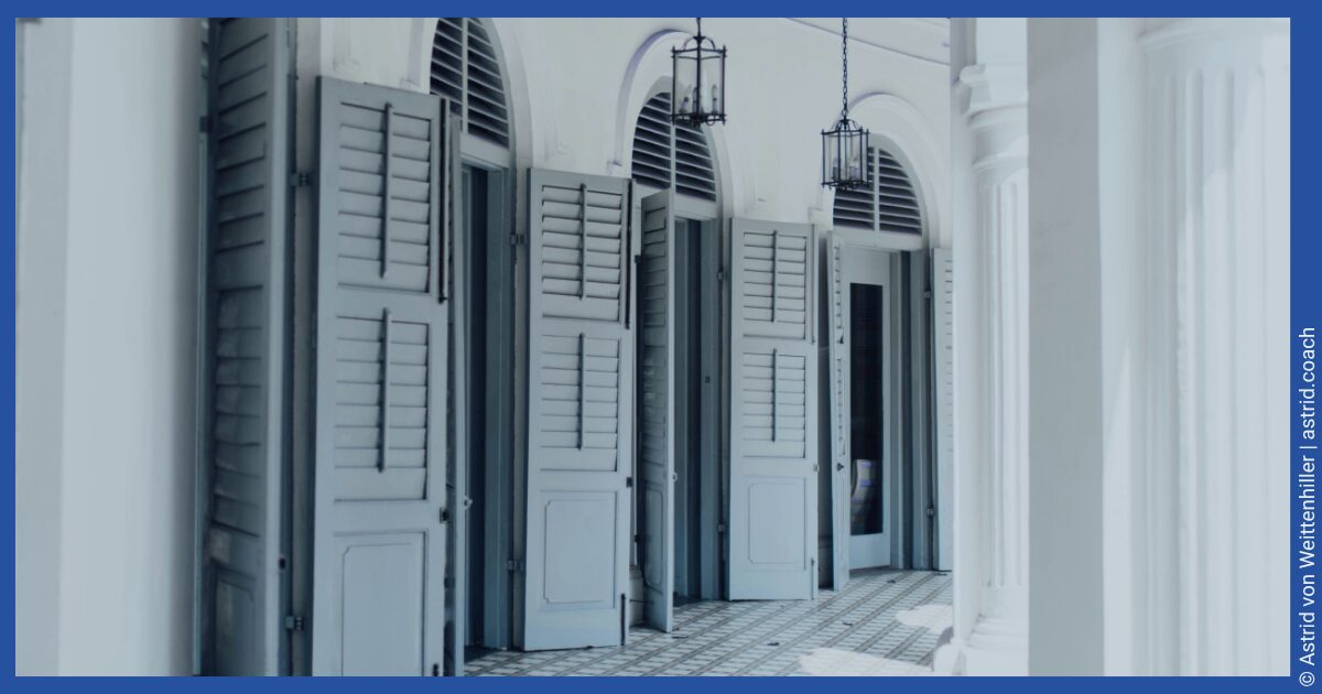Deutsch: Kolonnadengang mit grauen Fensterläden und hängenden Laternen - English: Colonnaded walkway with gray shutters and hanging lanterns